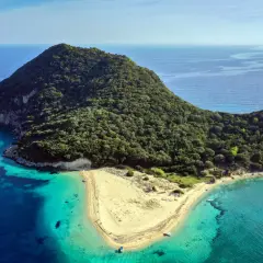 Malownicza wyspa żółwi Zakynthos, porośnięta zielenią, z piaszczystą plażą i krystalicznie czystą wodą.